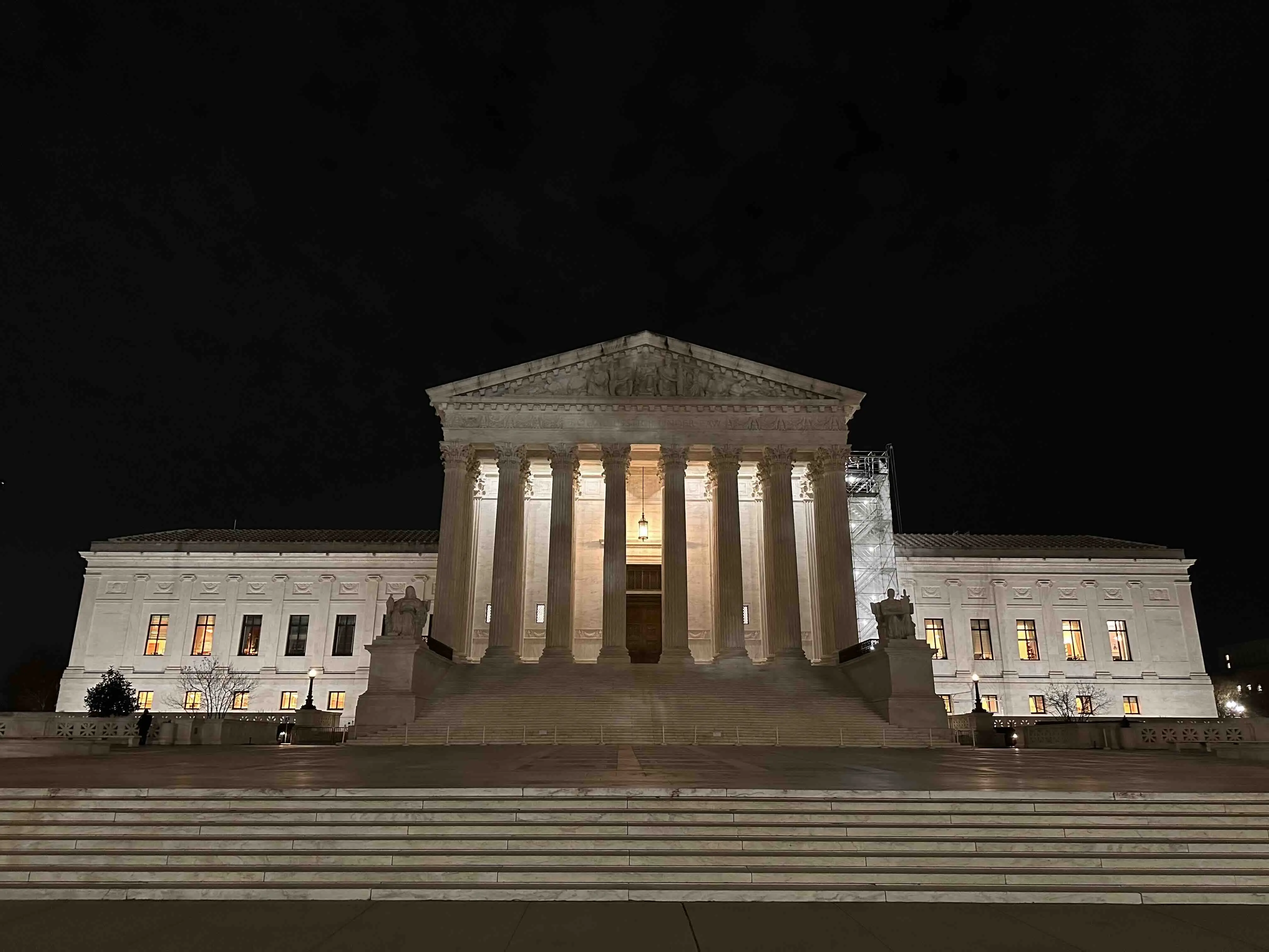The United States Supreme Court building illuminated at night